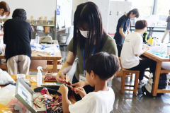 学生スタッフが子どもと一緒に材料の毛糸を選ぶ様子