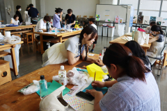 学生スタッフが親子に絵本製作のアドバイスをする様子