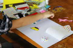 子どもが材料を切り貼りしながら絵本を制作する様子