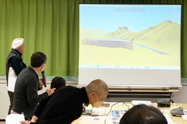 プレゼンテーションにてスクリーン画面を示しながら説明をする様子