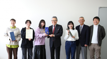 崔学松准教授と入賞した「チーム崔」の学生メンバー4名が、横山学長のもとを訪れ受賞の報告をしました。