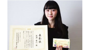 表彰状と作品を手にする受賞学生の様子