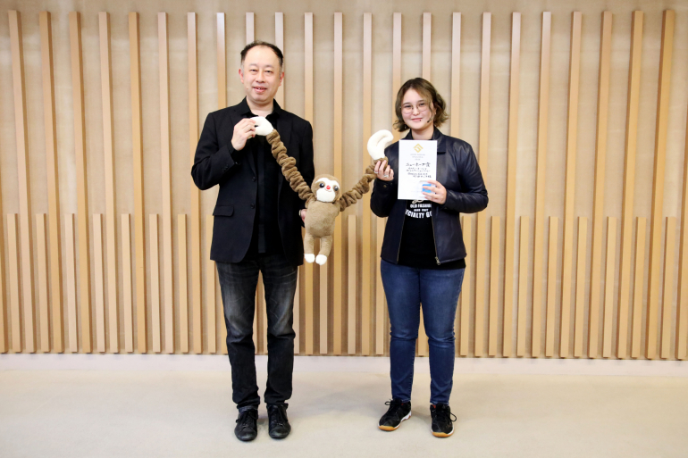 受賞作品を持った武田さんと中野教授