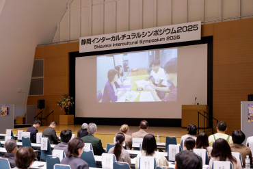 シンポジウムでポスター制作動画を見ている観客の様子