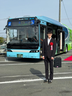 デザインをしたEVバスと山本さんの画像