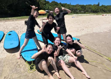 ビーチでサーフィンを楽しむ学生たち