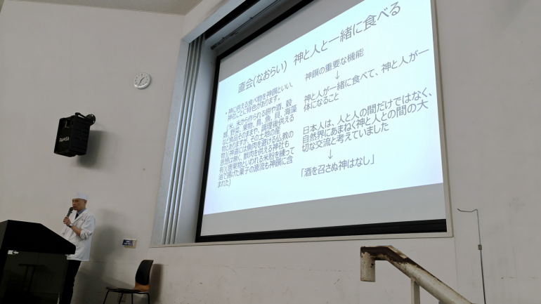 スライドを使用して説明する一木さんの様子