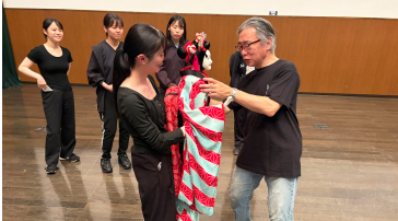 豊松清十郎さんから人形の扱い方の指導を受ける学生の画像